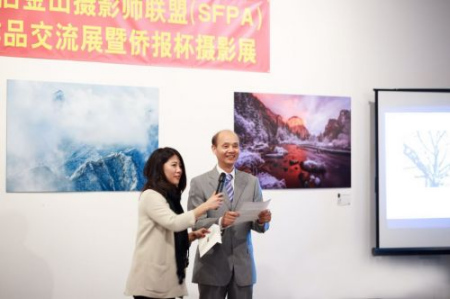 中国驻旧金山总领事罗林泉（右）在参加侨报杯摄影展开幕式上，揭晓一等奖获得者。左为美国中文电台节目主持人馨瑶。（美国《侨报》资料图）