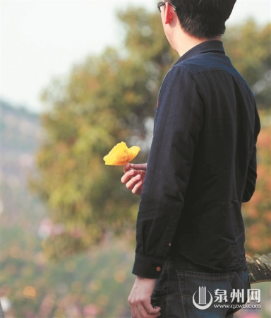 泉州宏福园,一位市民拿着黄色纸菊花准备祭拜逝者。(潘登/摄) 泉州宏福园,一位市民拿着黄色纸菊花准备祭拜逝者。(潘登/摄)