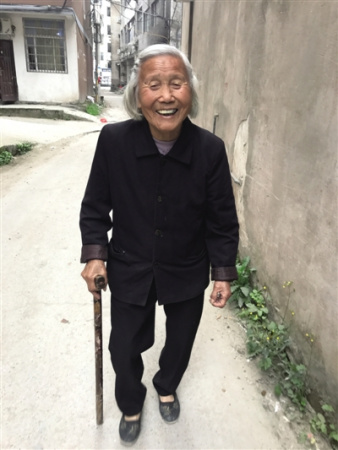 104岁的陈宣翠老人腿脚灵便,头上还有不少黑发,得知我们前来拜访,老人拄着拐杖快步带路。朝丹 摄 104岁的陈宣翠老人腿脚灵便,头上还有不少黑发,得知我们前来拜访,老人拄着拐杖快步带路。朝丹 摄
