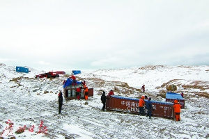 科考人员在南极搬运油桶。 
