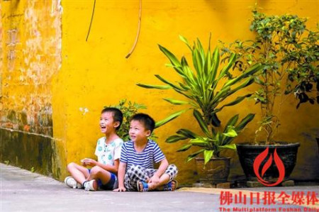 柏树巷黄色房子前，两位小朋友正在玩耍。/佛山日报记者王澍摄