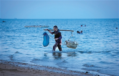 琼海市潭门镇海边，捕鱼归来的渔民。