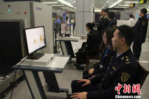 图为义乌局工作人员通过X光机查验旅客的行李 图为义乌局工作人员通过X光机查验旅客的行李