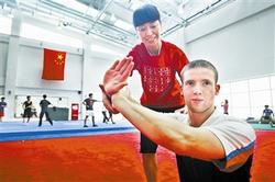 天津理工大学武术队教练徐彩桐指导柯蒂斯武术招式。(图片来源:天津《今晚报》) 天津理工大学武术队教练徐彩桐指导柯蒂斯武术招式。(图片来源:天津《今晚报》)