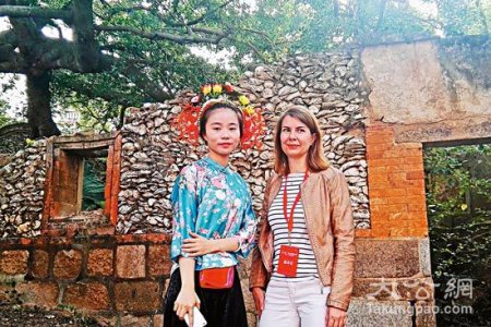 身穿蟳埔女传统服饰的王秀梅(左)与到访外国客人/受访者供图
