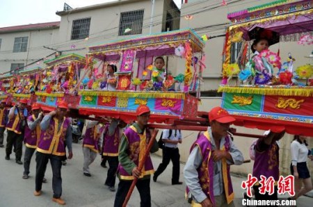 5月7日,厦门海沧蜈蚣阁民俗亮相保生大帝绕境巡安文化节。据了解,蜈蚣阁和闽台两地保生大帝文化密切相关,小孩子扮作金童玉女坐在“阁棚”内,由人力肩扛,缓缓前进,犹如一条大蜈蚣蜿蜒爬行。相传,当年保生大帝吴真人一生行医救济百姓,大多以蜈蚣为药引,后人为纪念他,形成了蜈蚣阁这种祭拜民俗。 张斌 摄 5月7日,厦门海沧蜈蚣阁民俗亮相保生大帝绕境巡安文化节。据了解,蜈蚣阁和闽台两地保生大帝文化密切相关,小孩子扮作金童玉女坐在“阁棚”内,由人力肩扛,缓缓前进,犹如一条大蜈蚣蜿蜒爬行。相传,当年保生大帝吴真人一生行医救济百姓,大多以蜈蚣为药引,后人为纪念他,形成了蜈蚣阁这种祭拜民俗。 张斌 摄