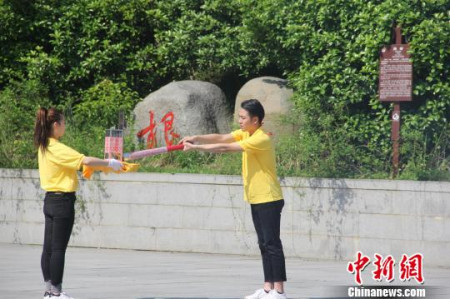 圣火采集手将火种对准圣火采集器,点亮火种灯。沈春艳 摄 圣火采集手将火种对准圣火采集器,点亮火种灯。沈春艳 摄