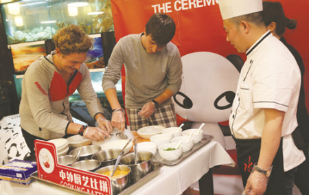 两名德国游客向水井坊四川酒楼行政主厨赵军(右一)学习制作凉粉。