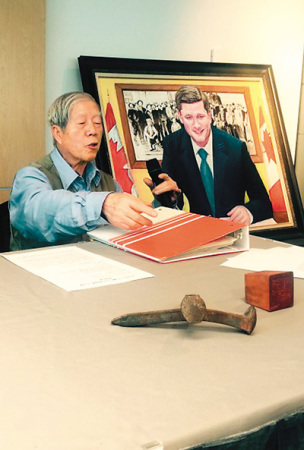图为伍胥山公所中文书记伍侠儒展示最后一根路钉和纪念章。（图片来源人民日报海外版）