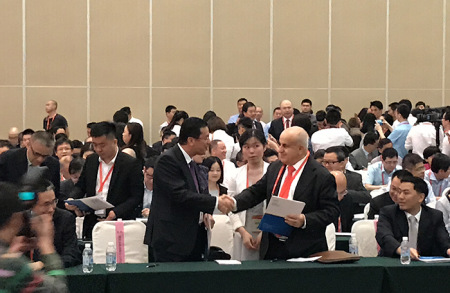 签约现场中外代表互相握手致谢。（图片来源：北京周报 马力摄）