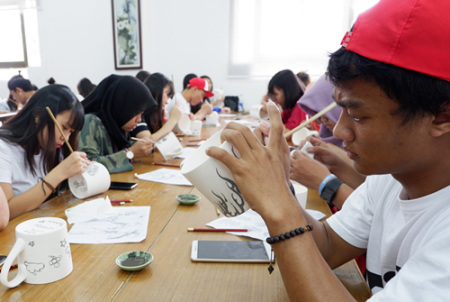 印度尼西亚学生正在绘制青花瓷茶杯图案。(华侨大学华文学院供图：杨惠晶 张芬妮)