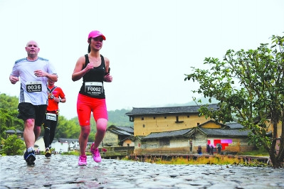 南靖土楼国际马拉松参赛者跑在风景中。