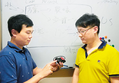 吴偲越（左一）与合伙人在讨论行车记录仪的上市方案。