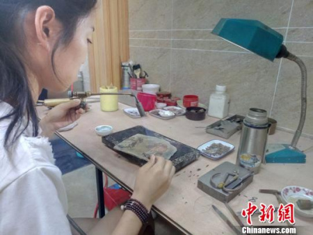 23岁的杨丽正在焊接银花丝制品。　王鹏 摄