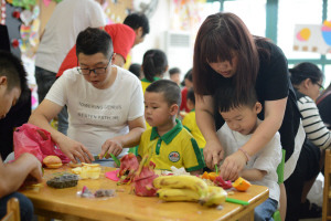 ④ 昨日，油竹街道慧果幼儿园举行“六一”畅享美食活动，让小朋友们度过一个难忘、愉快、有意义的节日。图为小朋友们在制作水果拼盘。张永益