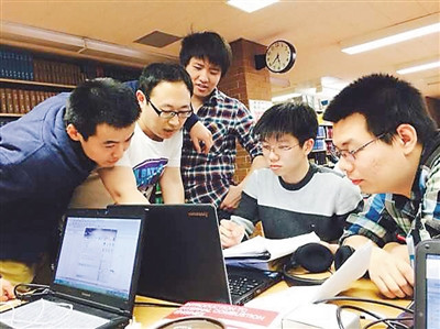 吴旭峰（右二）与同事在进行一项验证实验报告讨论。