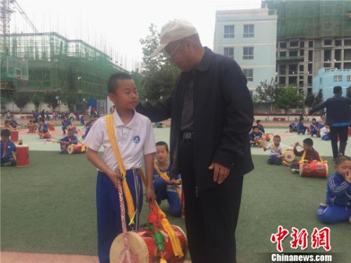 65岁的魏永宏被当地称为“兰州鼓王”，他也是学生们口中的“爷爷级”教练。魏永宏将太平鼓“搬进”学校，免费为孩子们传授这项“绝技”。　史静静 摄