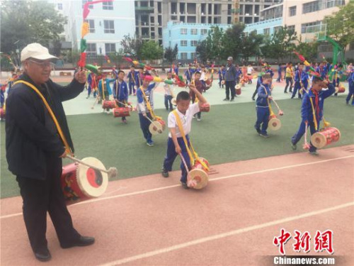 魏永宏一板一眼地指导孩子们打鼓的每个动作。　史静静 摄