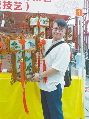 东艺宫灯省级非物质文化遗产传承人李仰东和他制作的宫灯。