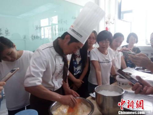 12日，20名归侨侨眷开始在山西新东方烹饪学校接受技能培训，学习西点烘焙。图为归侨侨眷学习做蛋糕。　郝延 摄