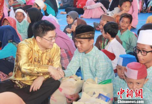 图为顾景奇向孤儿和贫困儿童发放礼包。 秦为芬 摄 图为顾景奇向孤儿和贫困儿童发放礼包。 秦为芬 摄