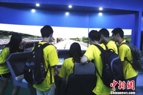华裔青少年在模拟仿真操作台上，模拟驾驶高铁列车。　朱柳融 摄