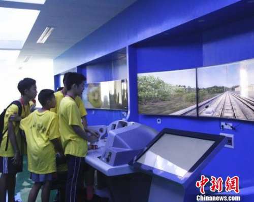 华裔青少年在模拟仿真操作台上，模拟驾驶高铁列车。　朱柳融 摄