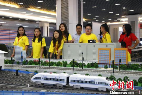 华裔青少年操作高铁运行沙盘系统，模拟车站值班员接发列车。　朱柳融 摄