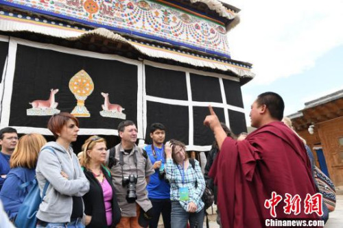 图为国外旅行商在夏河拉卜楞寺听取喇嘛讲解员的介绍。　杨艳敏 摄