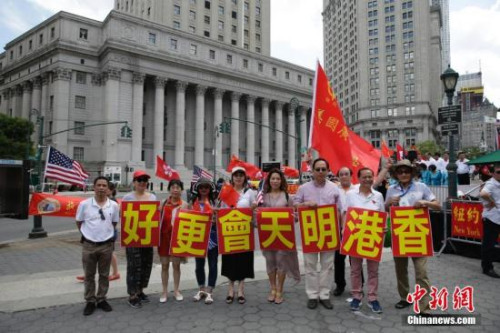 当地时间6月25日，美东各界华侨华人庆祝香港回归二十周年大会在纽约曼哈顿弗利广场举行。图为参会华人华侨打出“香港明天会更好”标语。<a target='_blank' href='http://www.chinanews.com/'>中新社</a>记者 廖攀 摄