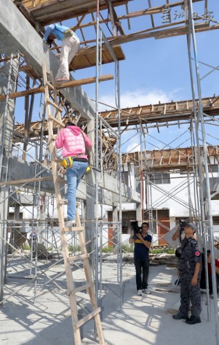 在建筑工地工作的外劳，从建筑中的屋宇楼上爬梯子下楼接受调查。(马来西亚《星洲日报》)