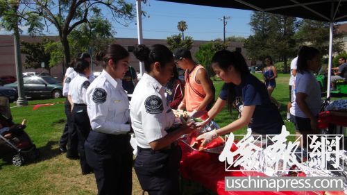 华裔女孩在史密斯公园做义工，为参加“儿童日”活动的青少年提供免费午餐。（美国《侨报》/高睿 摄）