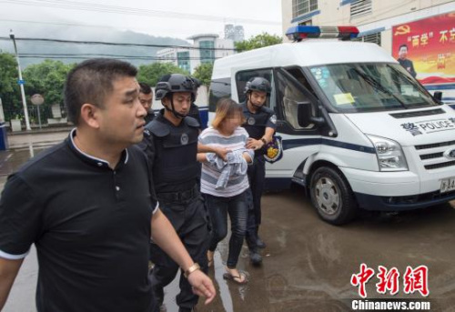 警方将胡某霞押解回国。 杭州警方供图 警方将胡某霞押解回国。 杭州警方供图