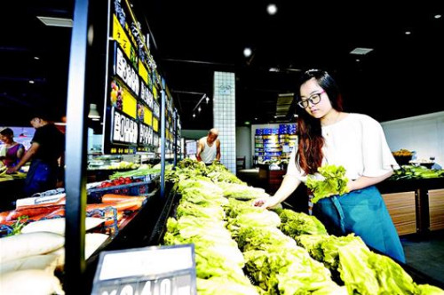 李雨河借鉴国外经验在社区开设高端生鲜超市，依托家庭种植基地减少中间环节，形成产销一条龙。 (倪娜 摄)