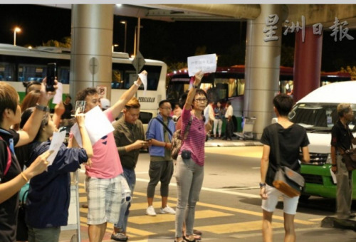 沙巴导游协会主席梁玉婉（面向镜头者右）带领约30名导游在亚庇国际机场入境厅门口展开杯葛“黑导”纠察行动。（马来西亚《星洲日报》）