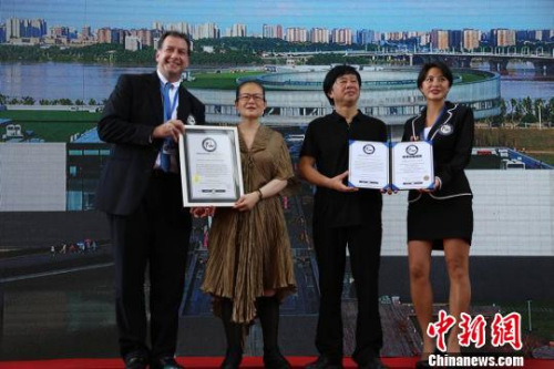 李自健夫妇从世界纪录认证官手中接过证书。 刘享 摄 李自健夫妇从世界纪录认证官手中接过证书。 刘享 摄