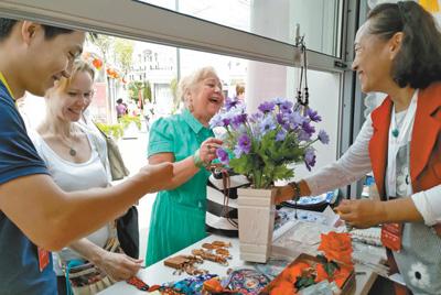 在莫斯科的北京地坛庙会上,北京民间工艺美术大师、绢花工艺传承人徐汶静(右一)带来的传统绢花颇受欢迎。本报记者 吴 焰摄 在莫斯科的北京地坛庙会上,北京民间工艺美术大师、绢花工艺传承人徐汶静(右一)带来的传统绢花颇受欢迎。本报记者 吴 焰摄
