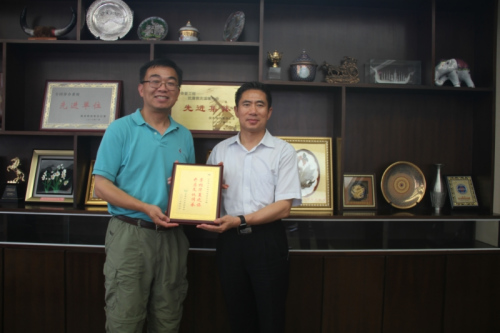 全美中文学校协会副会长胡国荣(左)向省侨办副主任孙传尚赠送感谢状