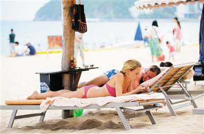 俄罗斯游客在大东海景区海滩上享受闲适时光。本报记者 武威 摄