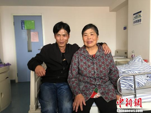 图为曾贵南(左)在医院照顾刚刚做完手术的何氏凤(右) 陈静 摄