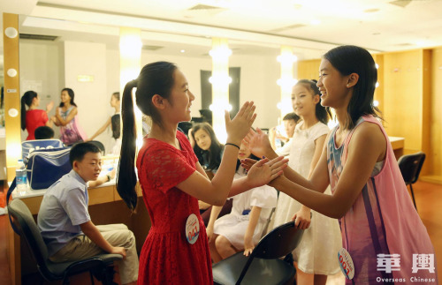 7月27日，选手们在2017年“文化中国·水立方杯”海外华人中文歌曲大赛初赛开始前于化妆间做游戏，缓解紧张气氛。(图片来自华舆 卞正锋 摄)