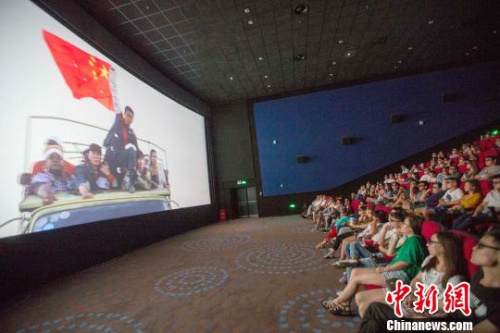 资料图:影片《战狼》中冷锋(男主角)举着中国国旗安全通过交战区。 张云 摄 资料图:影片《战狼》中冷锋(男主角)举着中国国旗安全通过交战区。 张云 摄