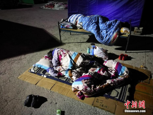 8月10日凌晨2时许，记者抵达四川阿坝州九寨沟地震灾区，随即走进永乐镇清平三村村委会、梨花广场避难场所探访，众多民众为躲避余震，一家人挤在一起睡在露天广场，深夜气温仅有13度。<a target='_blank' href='http://www.chinanews.com/' >中新网</a>记者 陈文 摄