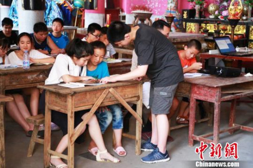图为美国华裔少年为当地孩子们教授英语。 陈水莲 摄 图为美国华裔少年为当地孩子们教授英语。 陈水莲 摄