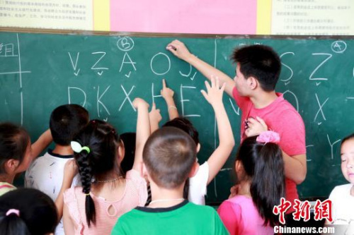 图为美国华裔少年为当地孩子们教授英语。 陈水莲 摄 图为美国华裔少年为当地孩子们教授英语。 陈水莲 摄