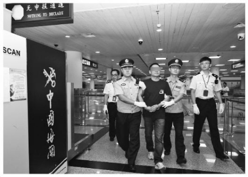 图为拱北海关缉私警察将纪某押出机场海关通道。张建林 摄 图为拱北海关缉私警察将纪某押出机场海关通道。张建林 摄