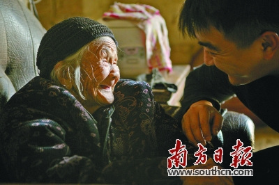 在纪录电影《二十二》片中，韦绍兰老人(左)在和导演郭柯交流