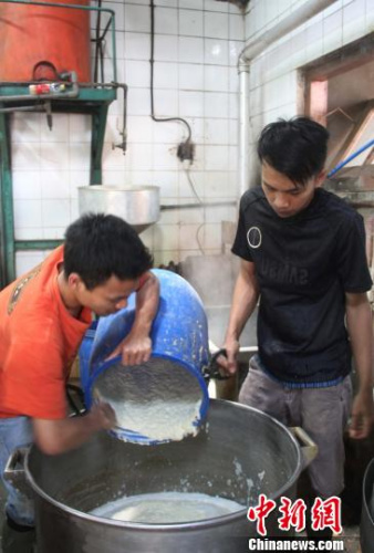图为工人正在磨豆浆。 林永传 摄 图为工人正在磨豆浆。 林永传 摄