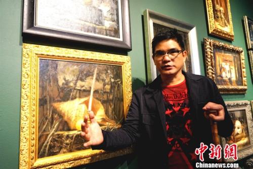 画展的主人、菲律宾画家阿瑞奥拉(DANILO ARRIOLA)每天坐在轮椅上迎接参观者。 关向东 摄 画展的主人、菲律宾画家阿瑞奥拉(DANILO ARRIOLA)每天坐在轮椅上迎接参观者。 关向东 摄