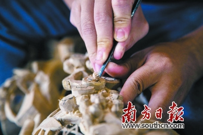 意溪镇的工匠正在雕刻木雕作品。董天健 肖雄 摄